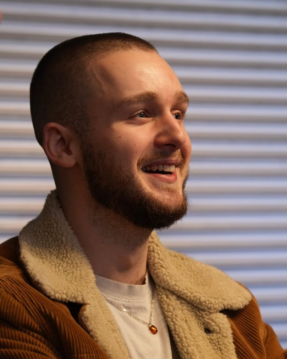 Portrait de Marlon Ghelfi, souriant, en veste de velours